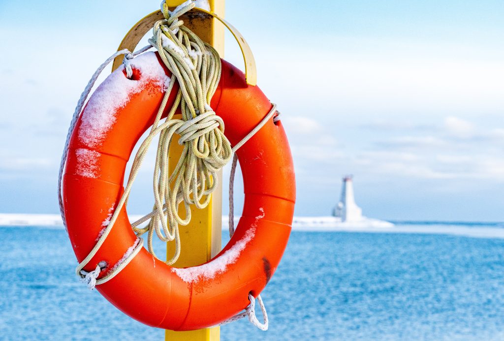 orange life preserver in winter with snow on it